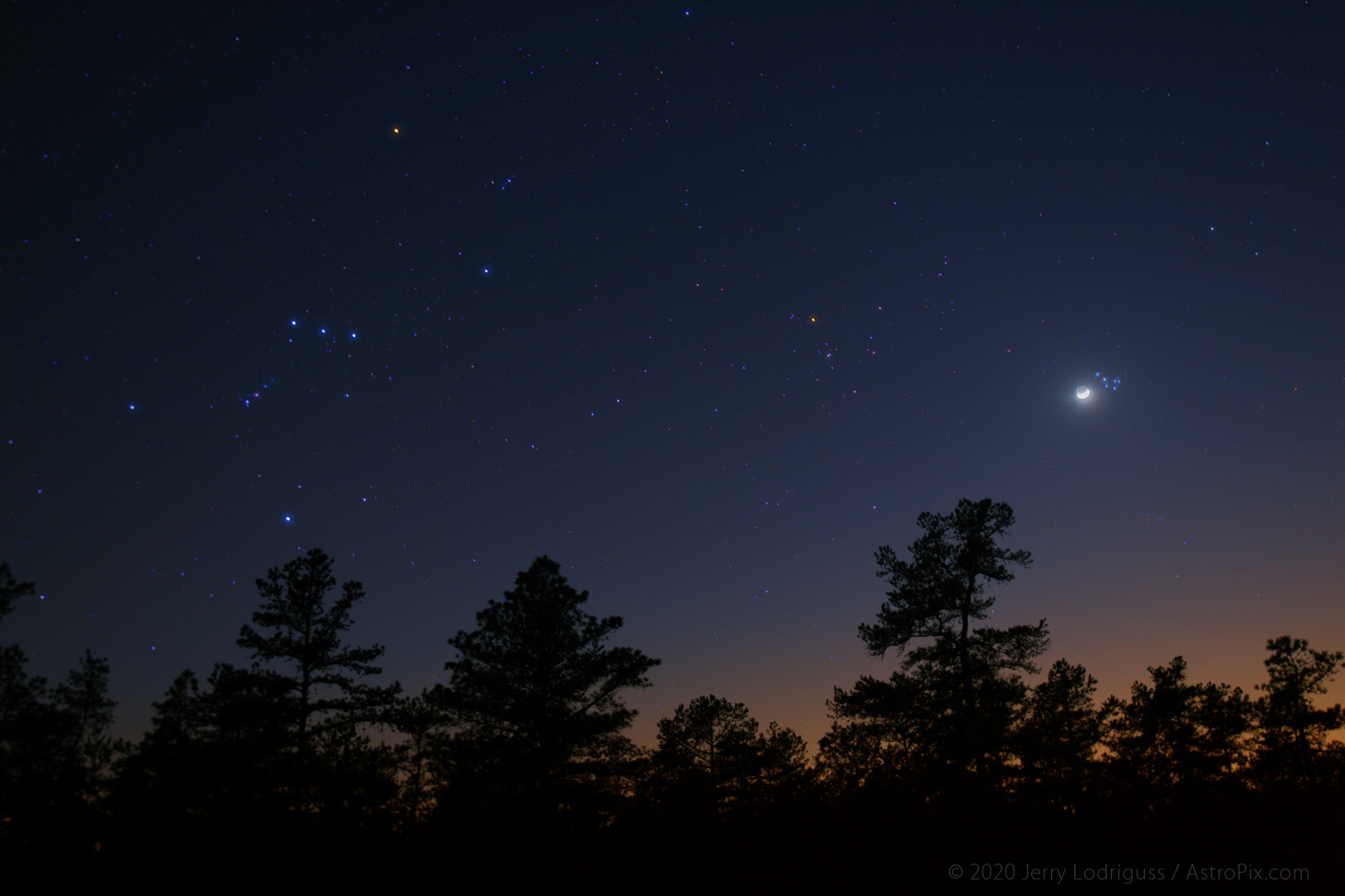 Orion and Taurus set in the west with the crescent Moon passing by M45, the Pleiades. This is a wide-field image shot with an 18mm lens. The next image shows what the Moon and M45 look like through a telescope.