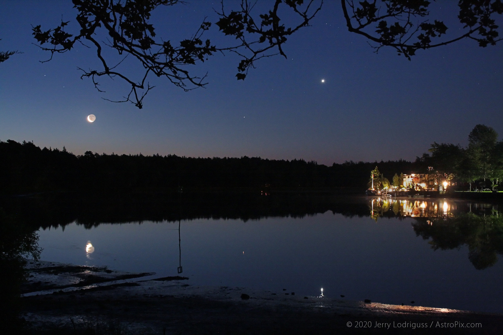 The Moon, Mars, and Venus are reflected in the still waters of the Mullica River in the Pine Barrens of New Jersey during morning twilight.