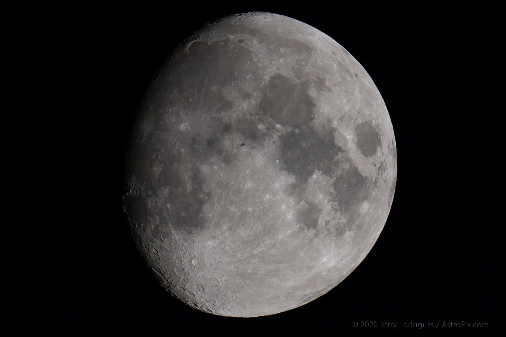 The International Space Station can be seen as a tiny black dot just above the center of the Moon as the ISS transits.