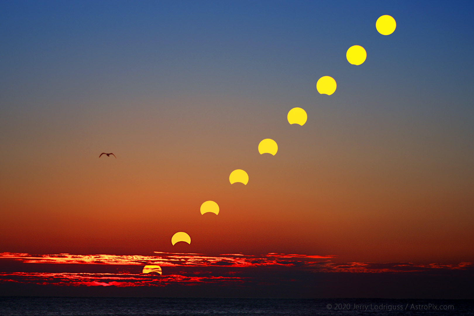The Sun rises partially eclipsed out of a cloud bank over the Atlantic ocean on November 3, 2013 in this multiple exposure digital composite image.
