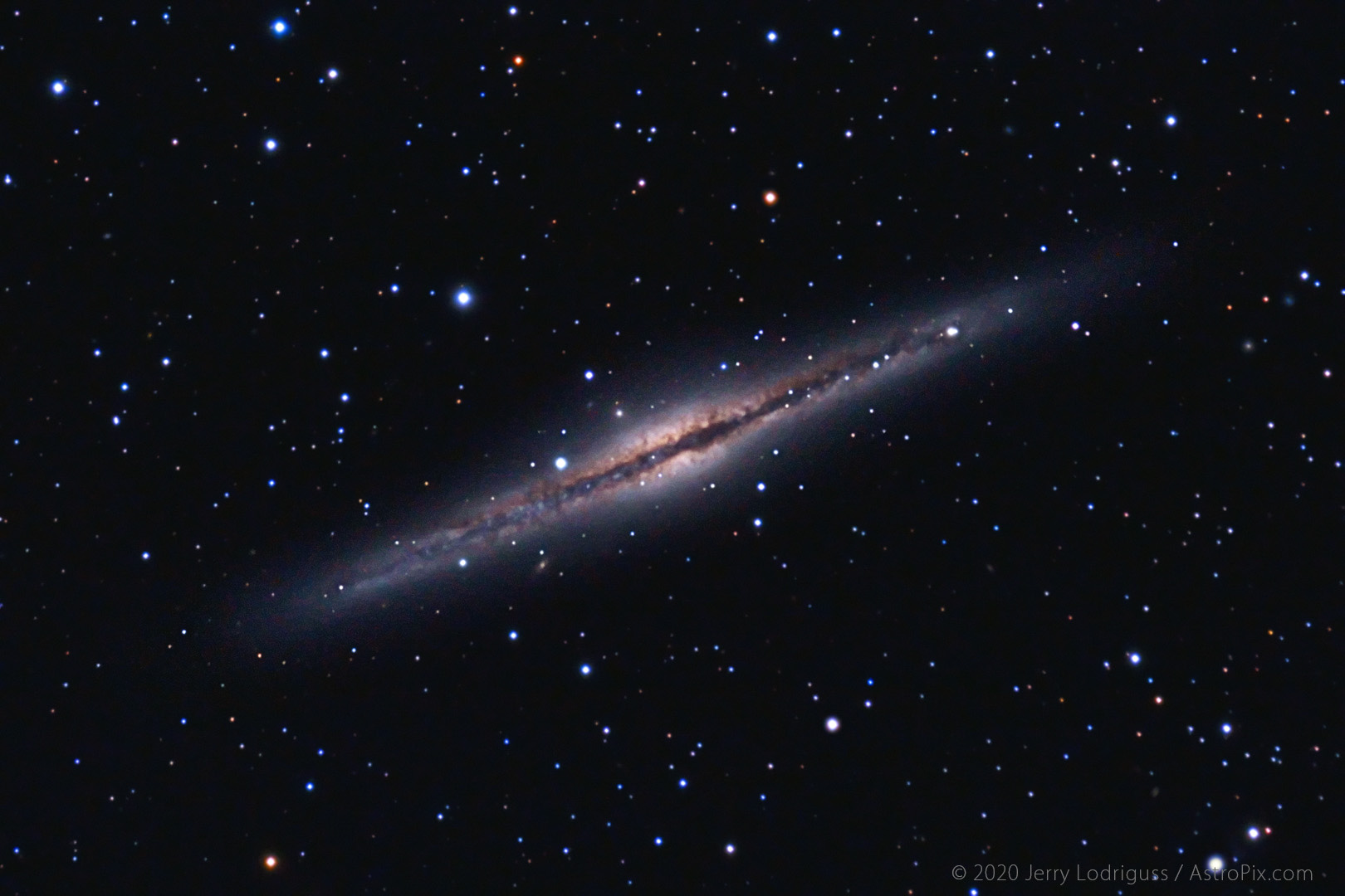 Galaxy NGC 891 is an edge-on spiral galaxy bisected by a dark lane. It is located in the constellation of Andromeda.