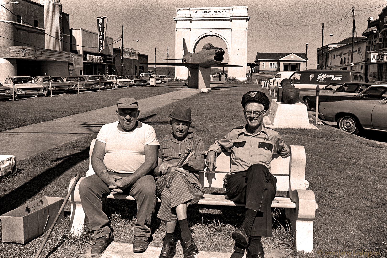 Three friends enjoy the morning sun in front of the Gretna courthouse.