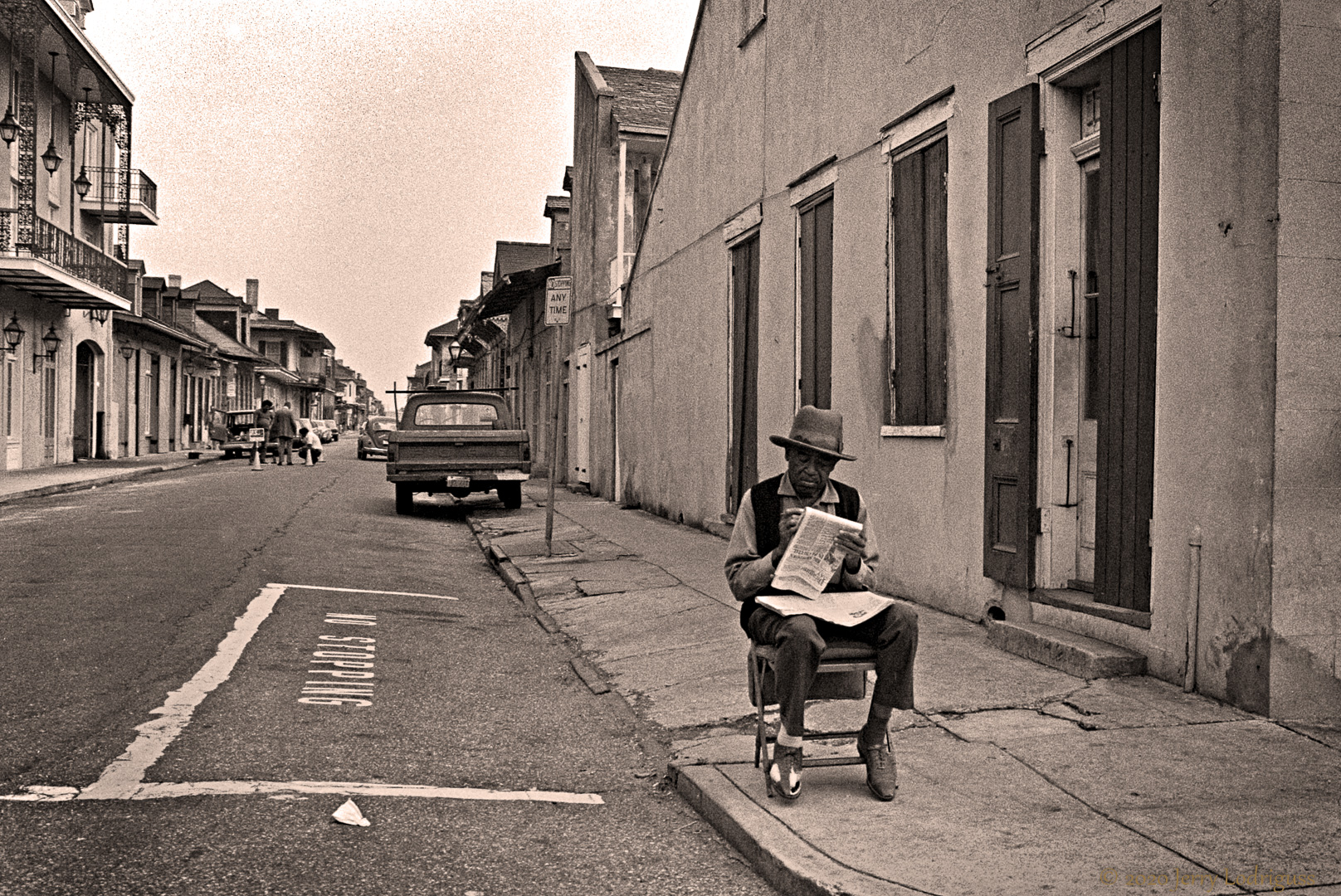 Man reading paper on a corner in the French Quarter, New Orleans.