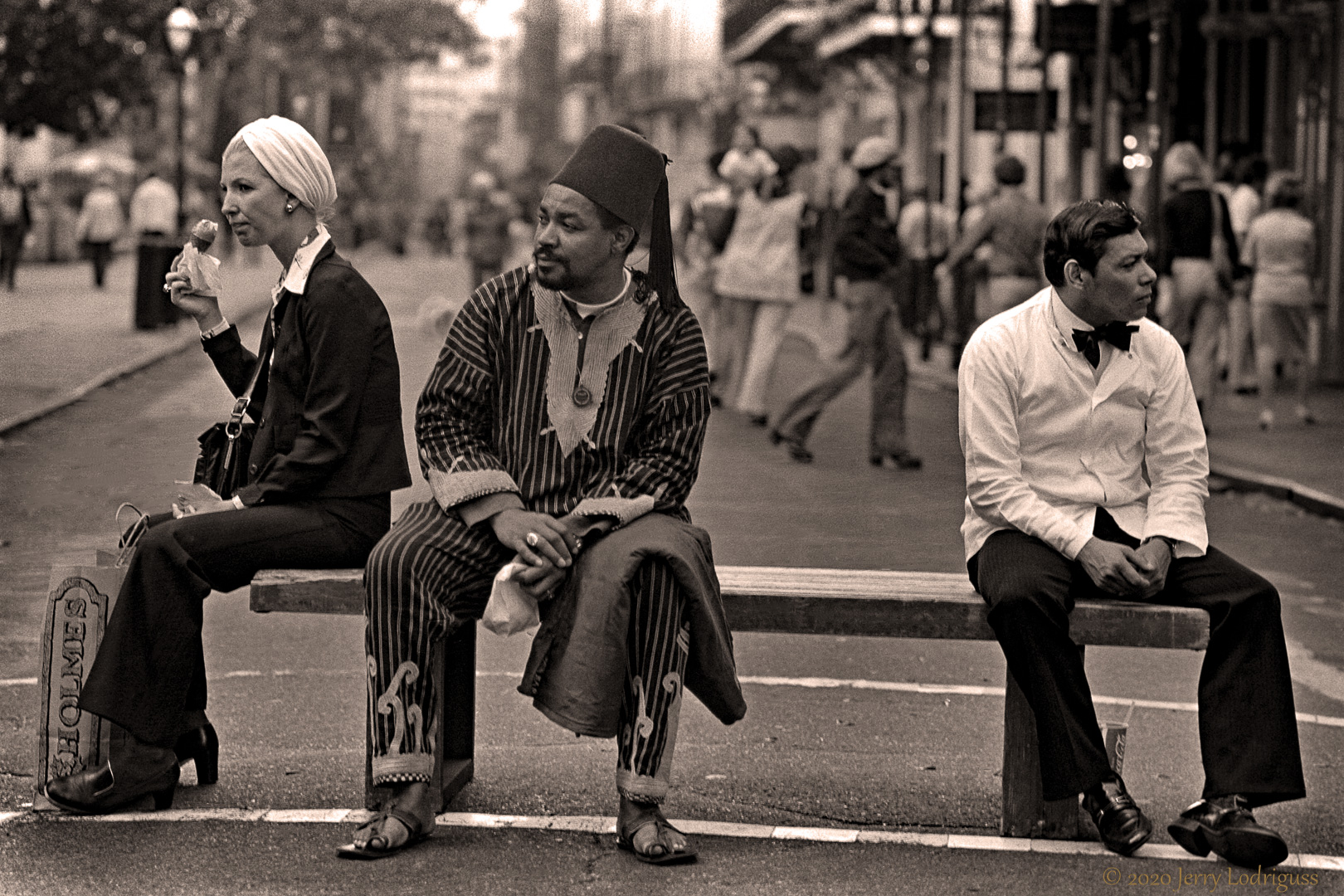 Three people on a bench, French Quarter.