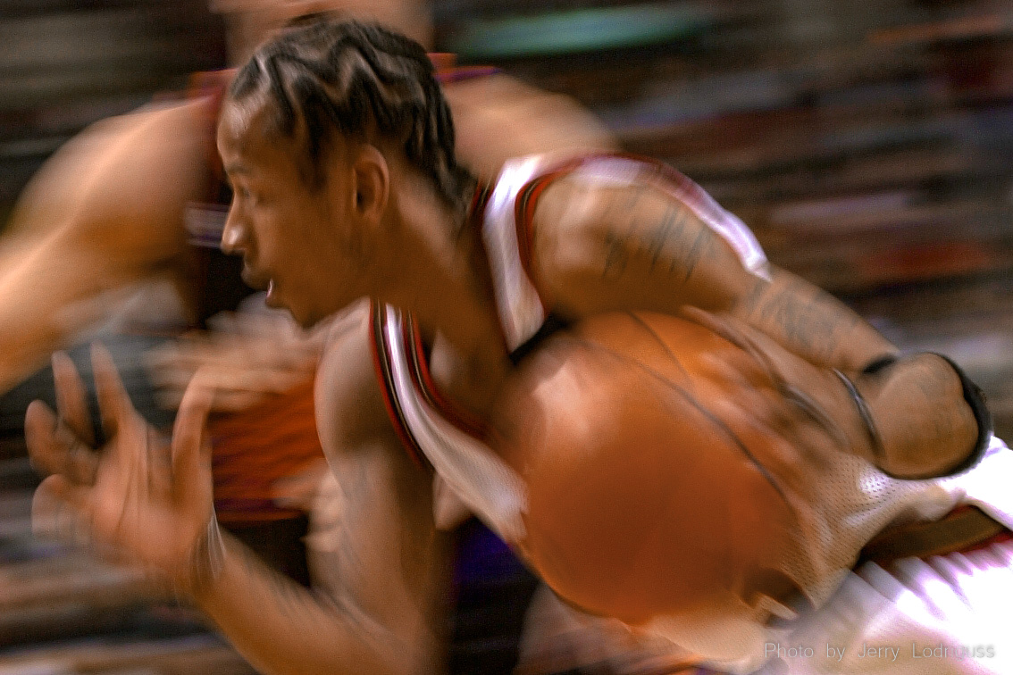 With the quickest first step in the NBA, the 76ers Allen Iverson is a blur in this slow-shutter-speed photo as he drives the baseline past Sun's Jason Kidd.