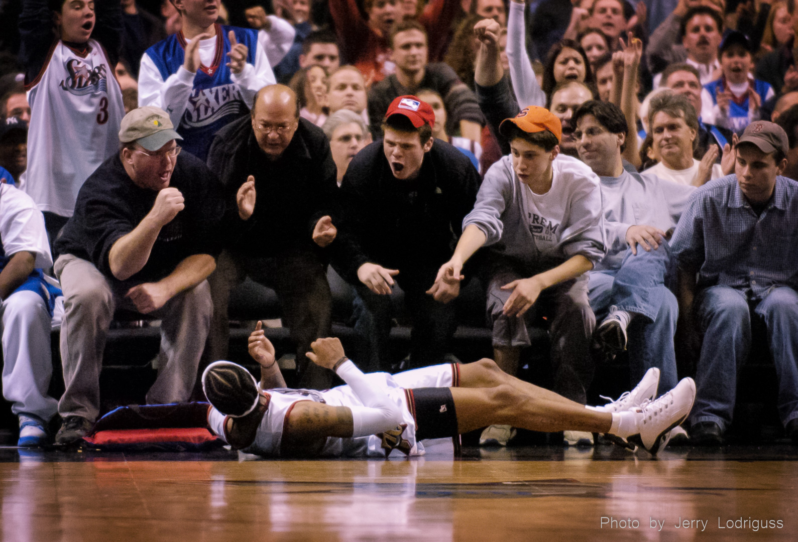 Sixers fans cheer for Allen Iverson who is flat on his back on the floor after being fouled while sinking a basket. Iverson made the free throw for a three point play. The Philadelphia 76ers faced the Detroit Pistons at the Wachovia Center in Philadelphia on Wednesday November 26, 2003.