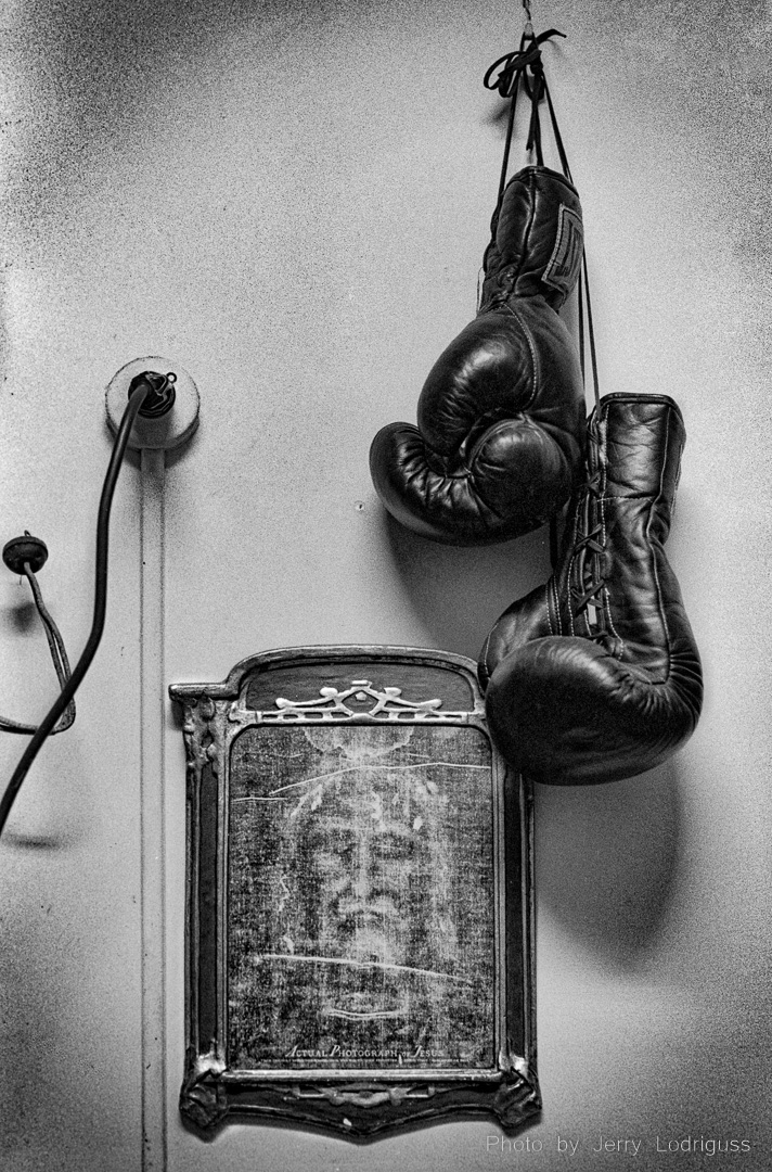 A pair of boxing gloves hangs next to a picture of Jesus in the office of the Blue Horizon Boxing Club in Philadelphia.