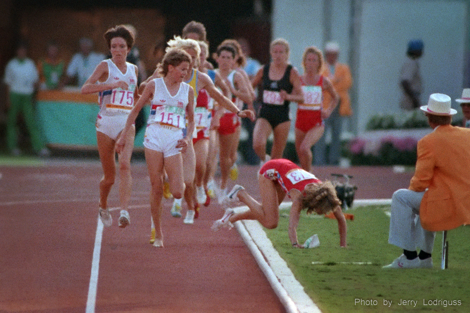 Britain's Zola Budd (151) watches the USA's Mary Decker fall to the infield after Decker became entangled with Budd's left leg when Decker tried to pass on the inside in the finals of the women's 3,000 meter run here August 10, 1984 at the Los Angeles Olympics.<br /><br />Budd, racing barefoot, trailed Decker for the first half of the race. She decided to pass Decker coming out of the third turn because the pace was too slow. As she cut in front, Decker got tangled up in Budd's left foot and fell to the infield, pulling the number off Budd's back as she fell.<br /><br />Budd, who had earlier that year broken Decker's world record in the 5,000 meters, was only 18 years old and at the center of a storm of controversy after leaving her home in South Africa to race under a British passport on the United Kingdom's Olympic team. South Africa was barred from competing in the Olympics at that time because of their apartheid policies.<br /><br />Decker, considered by many to be the greatest women's distance runner in the world at that time, having set six world records in 1982 at distances ranging from the mile to 10 000 meters, had her Olympic dreams crushed once again. Budd, who had taken over the lead after the collision, faded to finish seventh with tears coming down her face as she said she could not endure the boos of the crowd. Budd had considered Decker one of her heroes while growing up.