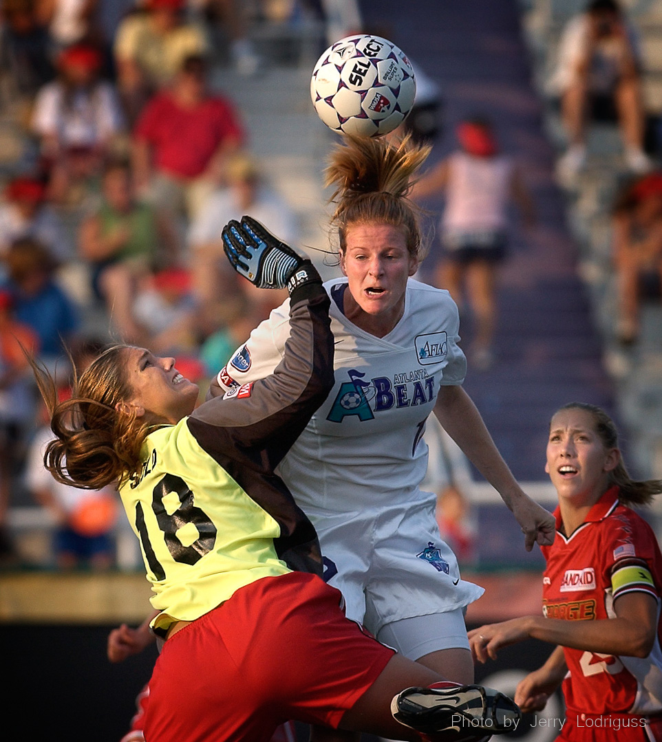 The Atlanta Beat's Cindy Parlow attempts to head the ball into the goal as the Philadelphia Charge's goalie Hope Solo comes out to make the stop. The Philadelphia Charge faced the first place Atlanta Beat  in Villanova, PA on July 16, 2003.